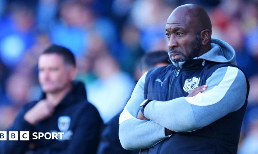Darren Moore stand with his arms crossed watching on from the touchline during a game