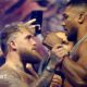 Jake Paul grabs Anthony Joshua's fist during a face-off