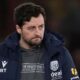 Ryan Mason sits in the dugout during a match