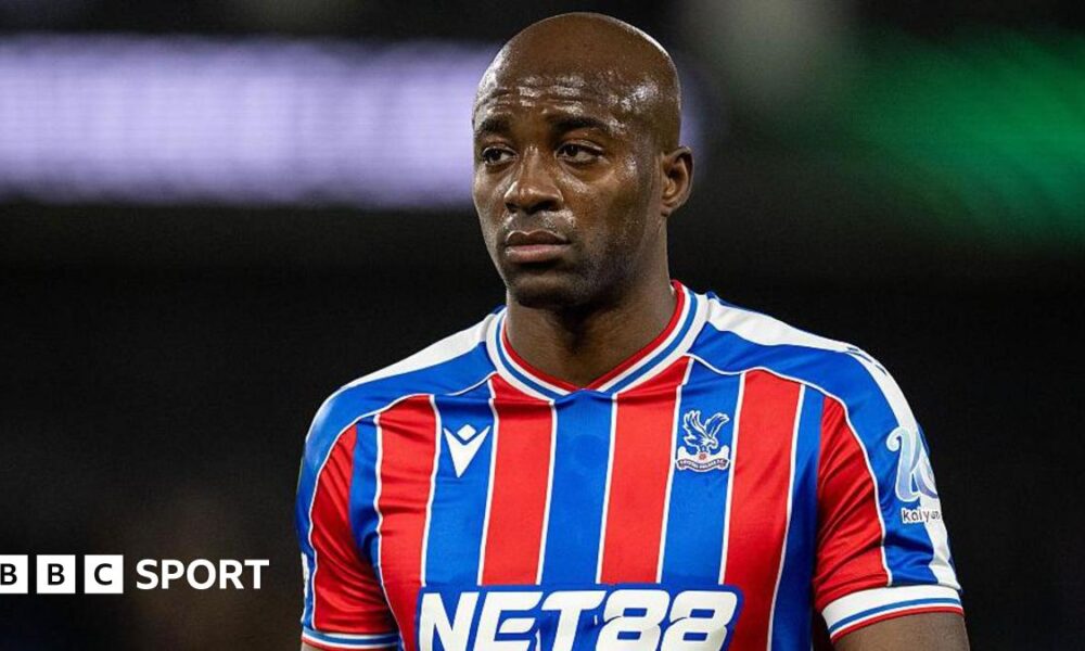Jean-Philippe Mateta wearing a blue and red striped Crystal Palace shirt
