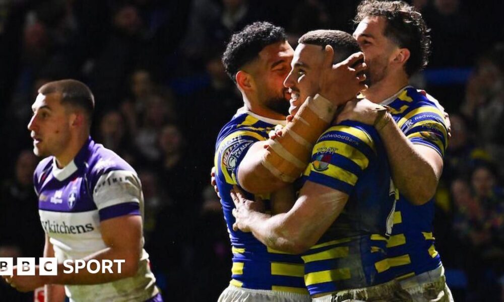Warrington Wolves player Josh Smith is congratulated by team-mates for scoring a try against Wakefield Trinity