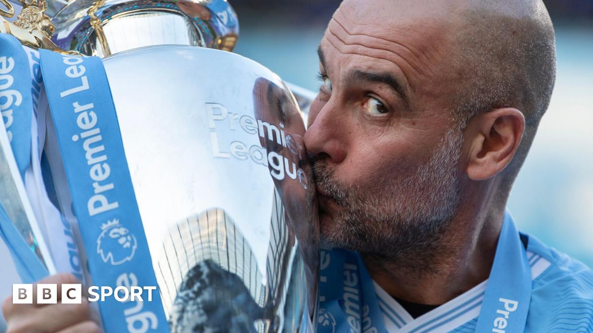 Pep Guardiola kisses the Premier League trophy