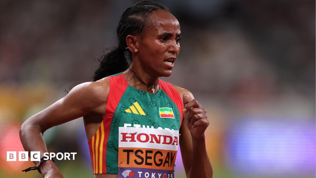 Gudaf Tsegay is seen from the waist up wearing an Ethiopia running vest with a bib with her surname and the Tokyo 2025 logo on the front of it. She looks foward in concentration while she runs