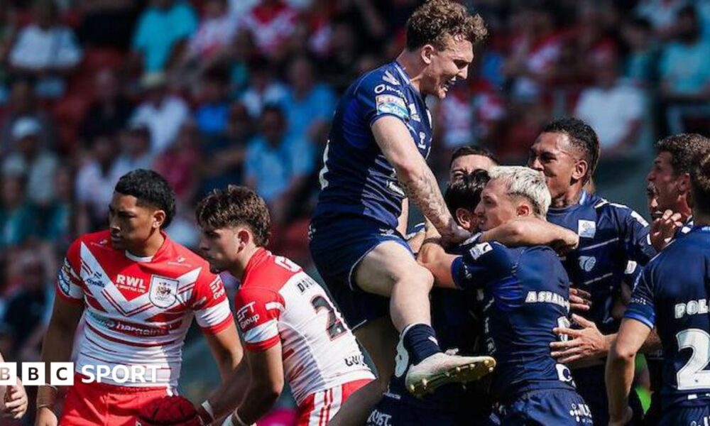 Toulouse players, in dark blue, celebrate a try against St Helens, two of whose players, in red and white, look disconsolate.
