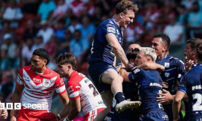 Toulouse players, in dark blue, celebrate a try against St Helens, two of whose players, in red and white, look disconsolate.