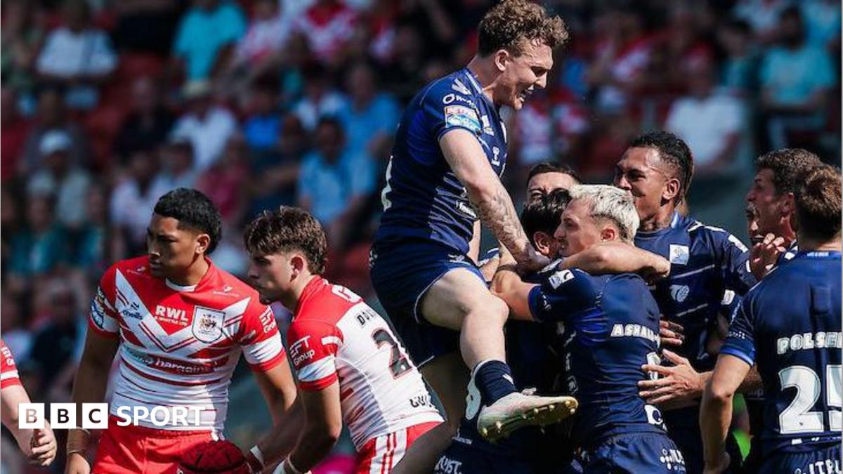 Toulouse players, in dark blue, celebrate a try against St Helens, two of whose players, in red and white, look disconsolate.
