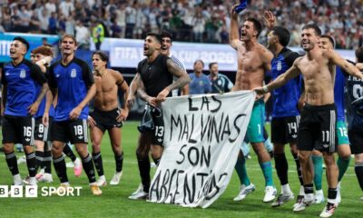 Argentina players celebrate at full-time with a banner that reads "The Falkland Islands are Argentine" after beating England in the World Cup 2026 semi-final