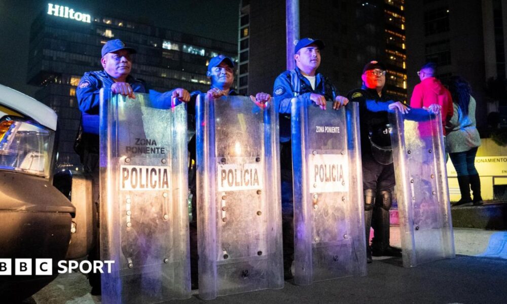 A row of riot police with shields