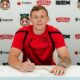 Wrexham's new goalkeeper Anthony Patterson signing papers at a desk