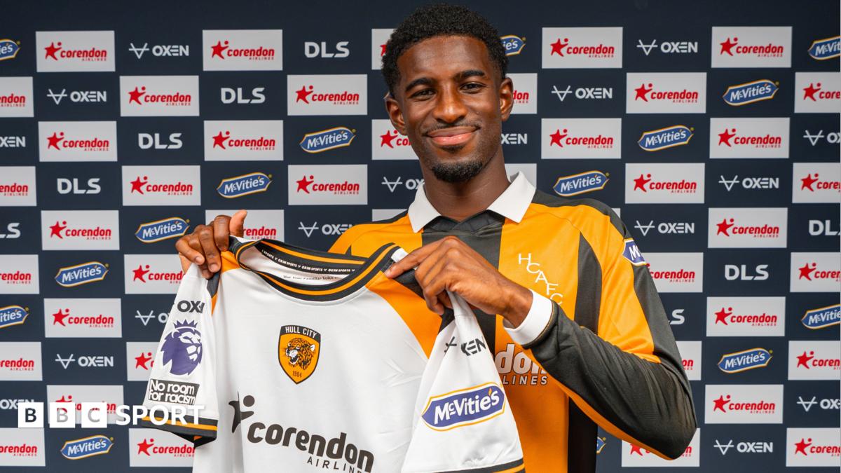 Hull City's new signing Mohamed-Ali Cho poses in the club's yellow and black home shirt, while holding up their white away strip