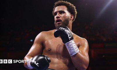 Moses Itauma holds up his hands and is wearing black boxing gloves