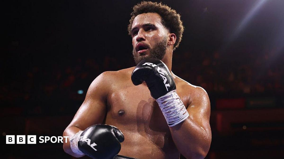 Moses Itauma holds up his hands and is wearing black boxing gloves
