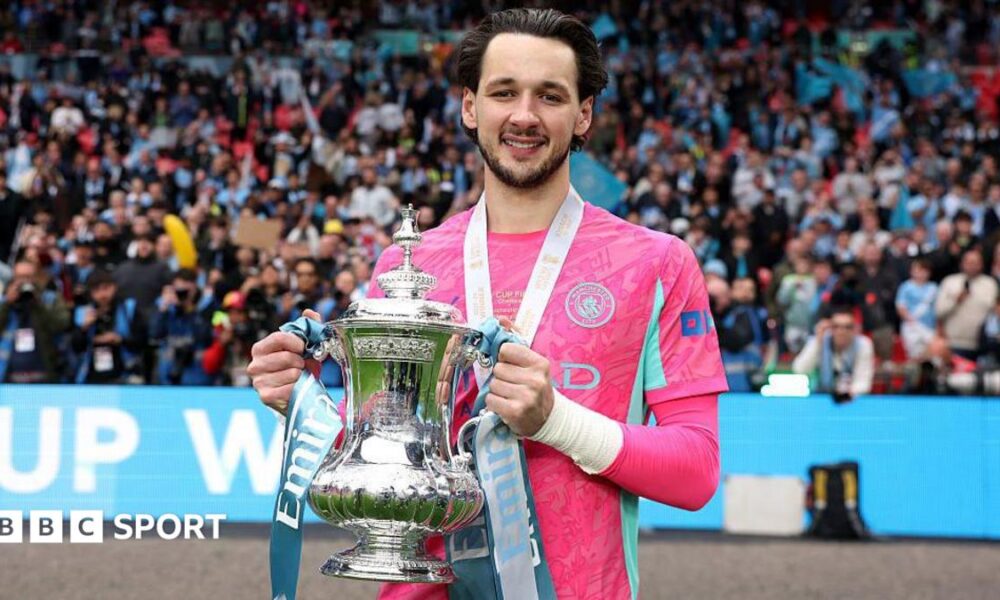 Manchester City goalkeeper James Trafford holding the FA Cup trophy at Wembley Stadium