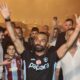 Mohamed Salah with a black Trabzonspor top on with his hands in the air outside Trabzon airport