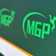 A large green sign with the MGP logo on it in pitlane.