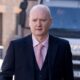 Graeme Dott arriving at the High Court in Glasgow. He is wearing a dark suit over a pink shirt witha pink tie.
