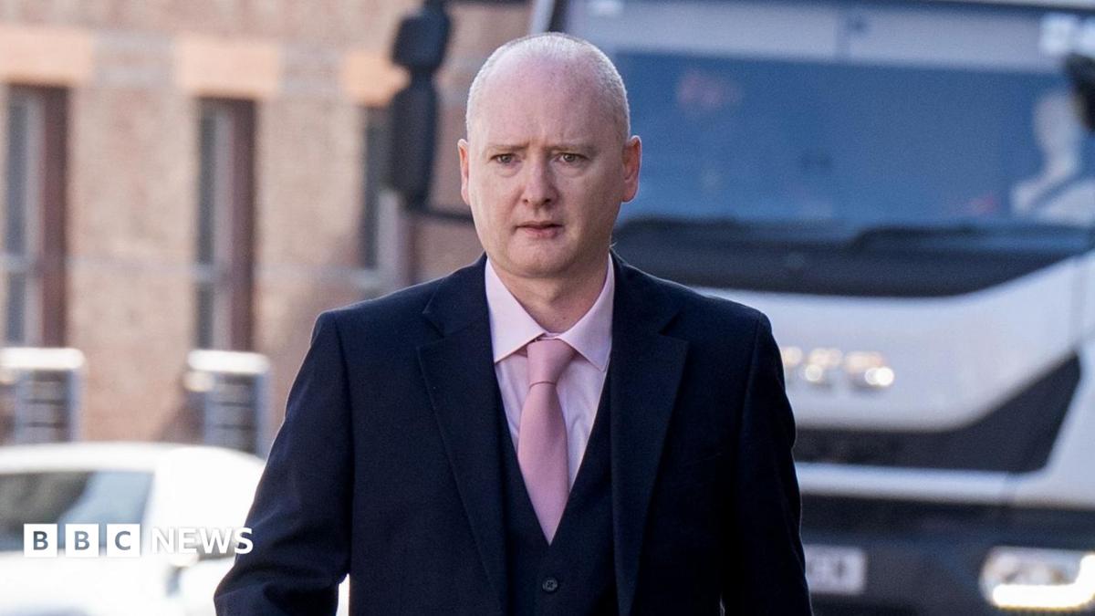 Graeme Dott arriving at the High Court in Glasgow. He is wearing a dark suit over a pink shirt witha pink tie.