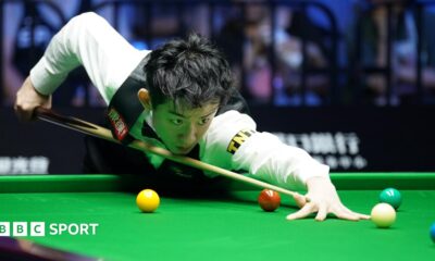 Snooker player Wu Yize takes aim as he plays a shot