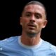 Jack Grealish, wearing Manchester City's sky blue kit, looks on during a match